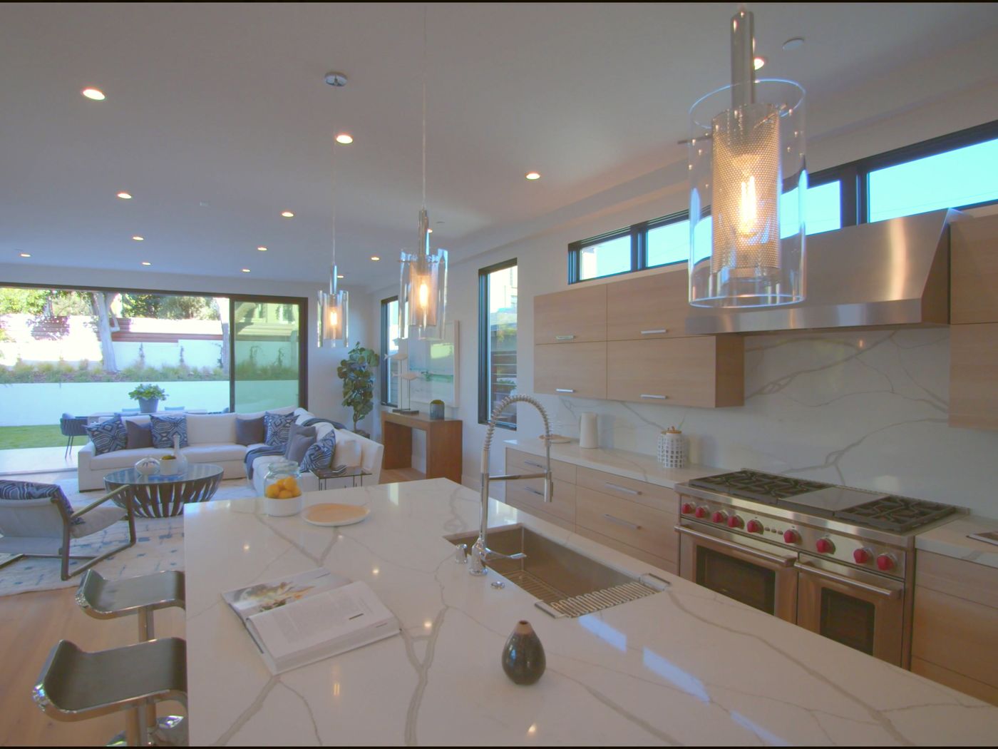 Kitchen with a marble island and professional range, photographed for a listing
